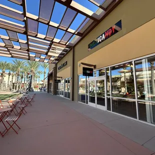 the outside of a restaurant with tables and chairs