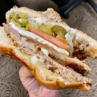 a hand holding a half eaten sandwich