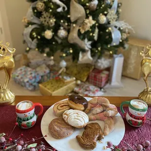 a plate of doughnuts on a table with a christmas tree in the background