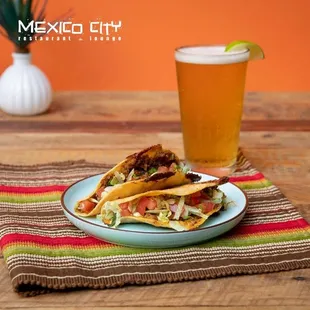 a plate of tacos and a glass of beer