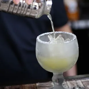 a margarita being poured into a glass