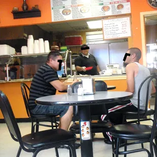 two men sitting at a table in a restaurant