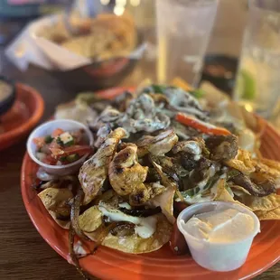 a plate of nachos with sauces