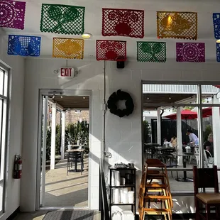 a mexican restaurant with colorful flags hanging from the ceiling