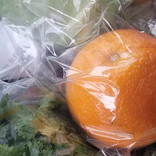 an orange in a plastic bag