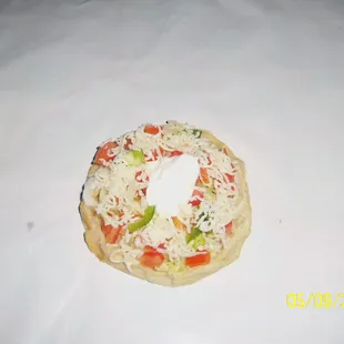 a small pizza with cheese and vegetables