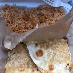 two quesadillas with rice and a fork