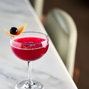 a glass of wine with a garnish garnish