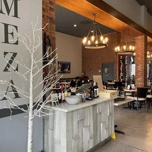 a restaurant with a bar and a tree in the middle of the room