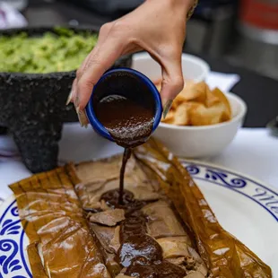 (INSIDE) Tamal de Mole: Chicken Tamal w/Mole Negro, wrapped in a banana leaf