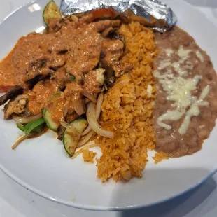 Mescalis Best  Steak, chicken and shrimp sautéed with peppers, onions, zucchini and mushrooms. Topped w/ creamy chipotle cheese sauce.