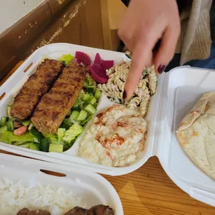 Beef Lula kabob place with salad, babaganoush and pasta salad.
