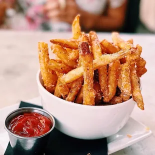 a bowl of french fries with ketchup