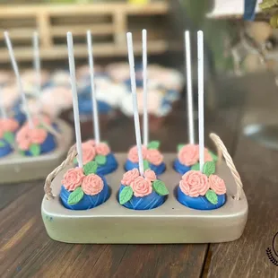 a tray of cupcakes with roses on them