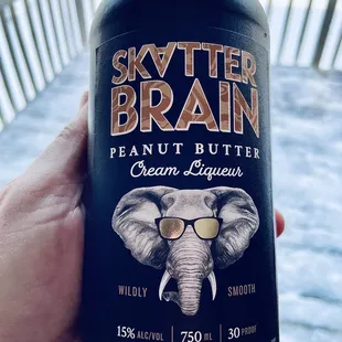  a hand holding a bottle of skyther brain peanut butter