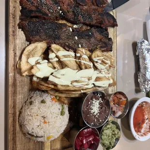 Riblets grill plate with rice,  fried banana, beans, pickled onion, guacamole, pico de gallo, salsa and tortillas $18