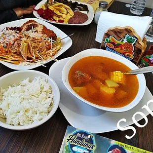 a bowl of soup, rice, and other foods on a table