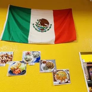 a mexican flag hanging on a yellow wall
