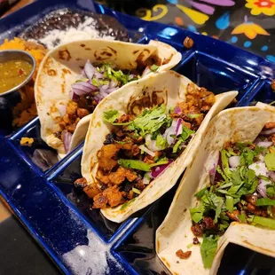 three tacos on a blue tray