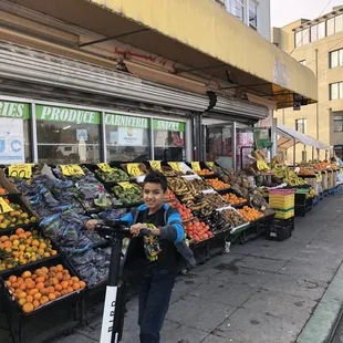 a woman standing in front of a fruit stand
