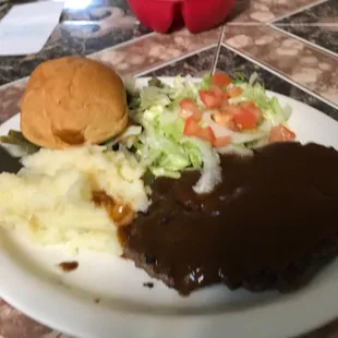 a plate of meat, mashed potatoes and gravy
