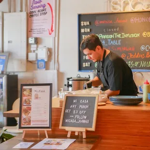 a man at the counter of a restaurant