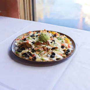 Mi Casa Nachos - black beans, asadero jack cheese, pico de gallo, green onions,
black olives, crema mexicana, guacamole, queso