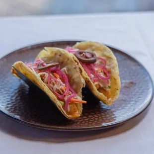 Baja Shrimp Tacos - sautéed chile garlic shrimp, tomatillo avocado salsa, asadero jack cheese, cabbage &amp; jicama slaw, pickled red onion