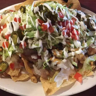 Heaping plate of fajita chicken nachos.