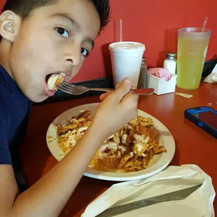 a young boy eating pizza