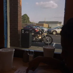 a child sitting at a table in front of a window