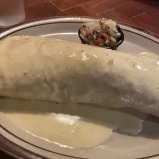 a burrito with a side of salsa