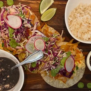 TACOS DE CAMARON Two shrimp tacos topped with fresh onions, guajillo peppers, oregano, chipotle, Oaxaca cheese, avocado salsa, and cabbage.