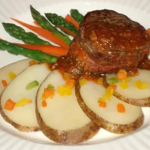 a plate of food with potatoes, asparagus, and meat