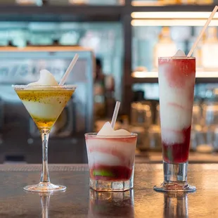 a variety of cocktails on a bar