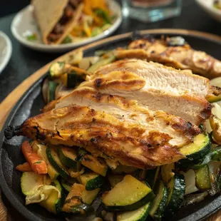 a plate of grilled chicken and vegetables