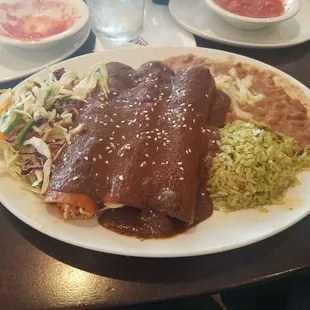 Mole chicken enchiladas with cilantro rice and beans
