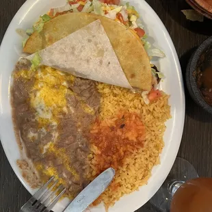 Shredded beef taco with rice and beans and also comes with a drink.