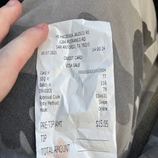 a hand holding a receipt