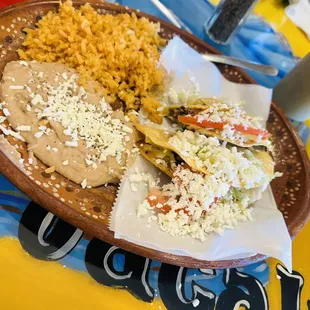2 ground beef tacos with a side of rice and beans.