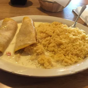 Chicken enchiladas and rice with cheese sauce