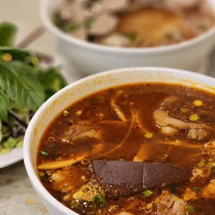 two bowls of soup and a salad