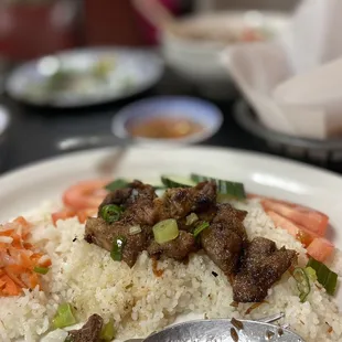 a plate of rice with meat and vegetables