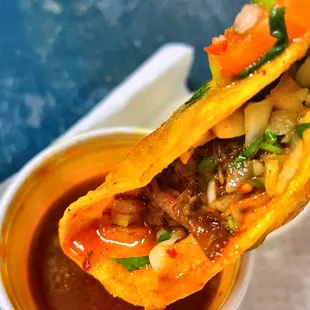 a hand holding a taco