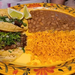 Steak and tongue tacos on hand made corn tortillas, rice and beans