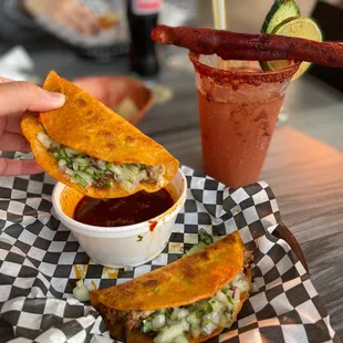 a person holding a sandwich and a drink