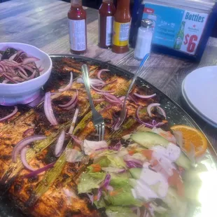 a pizza with onions, lettuce, and other toppings