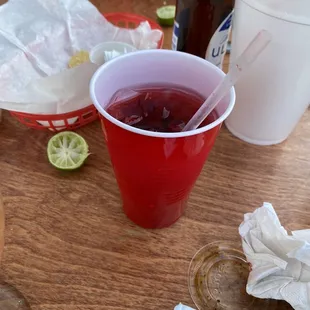 a red cup with a straw and a lime slice
