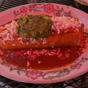 a plate of enchiladas with guacamole