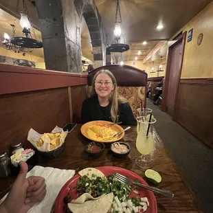 a woman sitting at a table with a plate of food